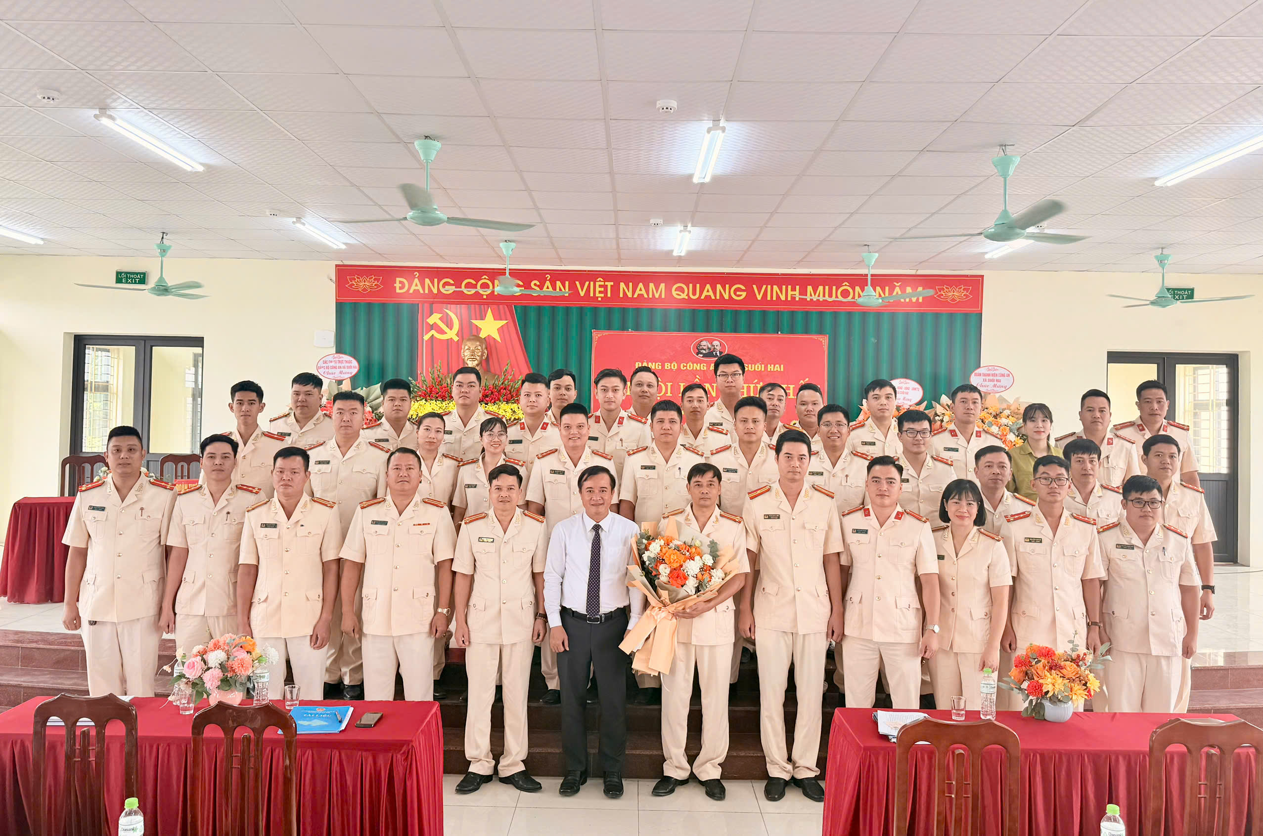 Đồng chí Đỗ Manh Hưng - Bí thư Đảng ủy - Chủ tịch HĐND xã tặng hoa và chụp ảnh lưu niệm cùng Đảng bộ Công an xã Suối Hai