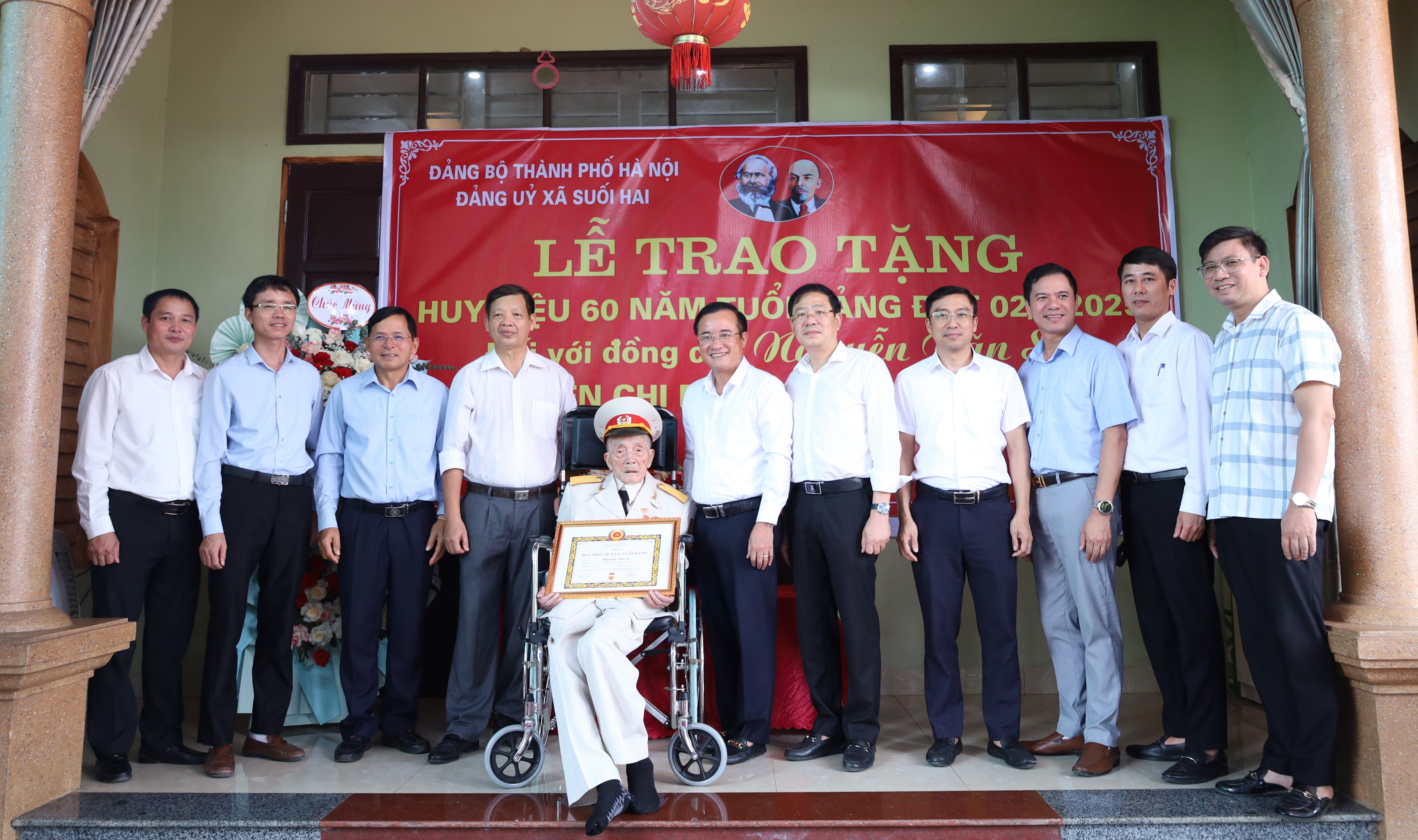 Các đồng chí lãnh đạo Đảng ủy, HĐND, UBND, Ủy ban MTTQ xã Suối Hai trao huy hiệu, tặng hoa và chụp ảnh lưu niệm cùng đảng viên Nguyễn Văn Sử