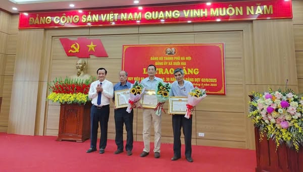 Đồng chí Đỗ Mạnh Hưng - Bí thư Đảng ủy - Chủ tịch HĐND xã trao hiệu cho đảng viên lão thành