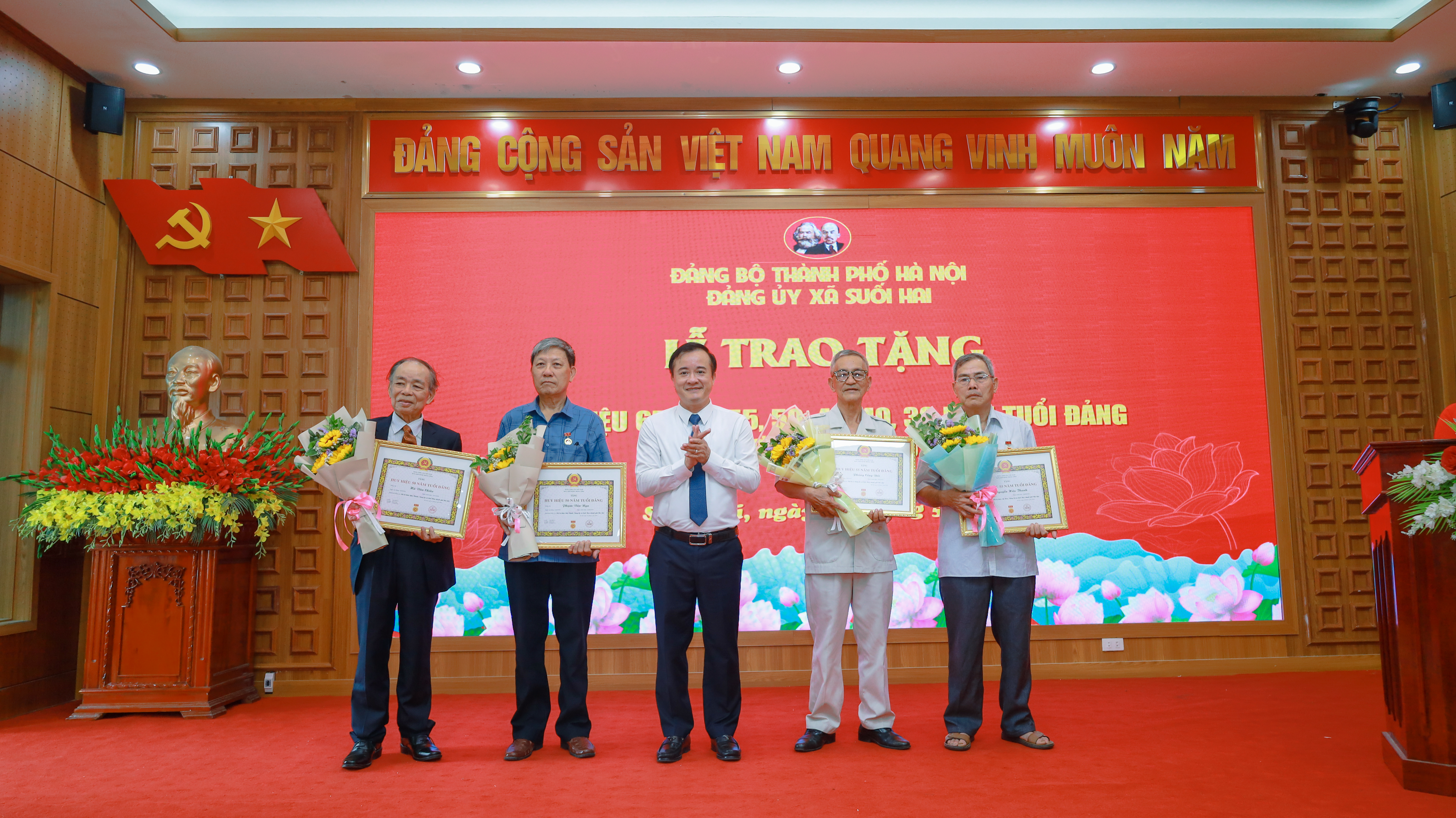 Đồng chí Đỗ Mạnh Hưng - Bí thư Đảng ủy - Chủ tịch HĐND xã trao huy hiệu đảng và tặng hoa cho các đảng viên 65 - 60 năm tuổi đảng