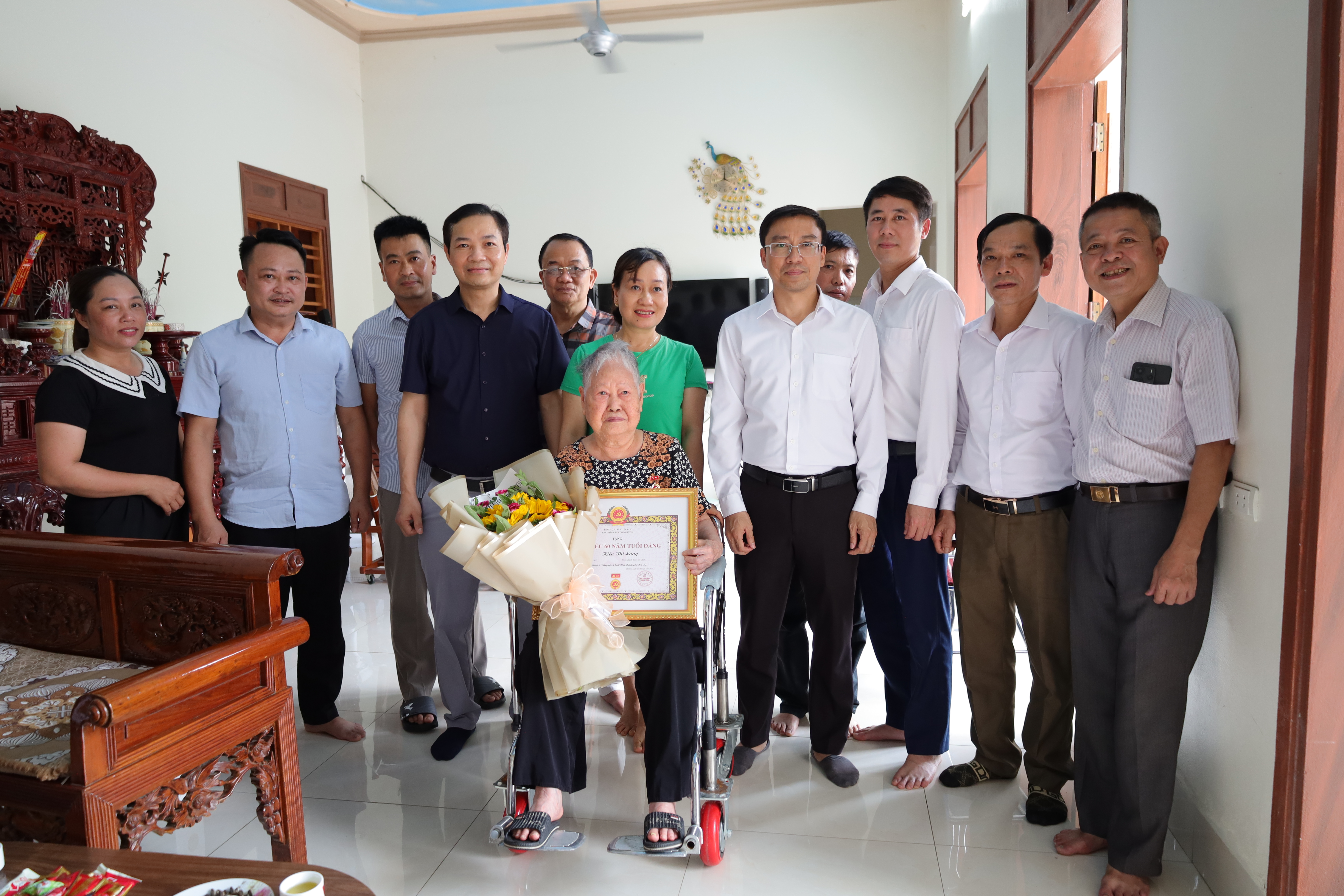 Các đồng chí lãnh đạo xã Suối Hai trao huy hiệu Đảng tại gia đình cho đảng viên lão thành