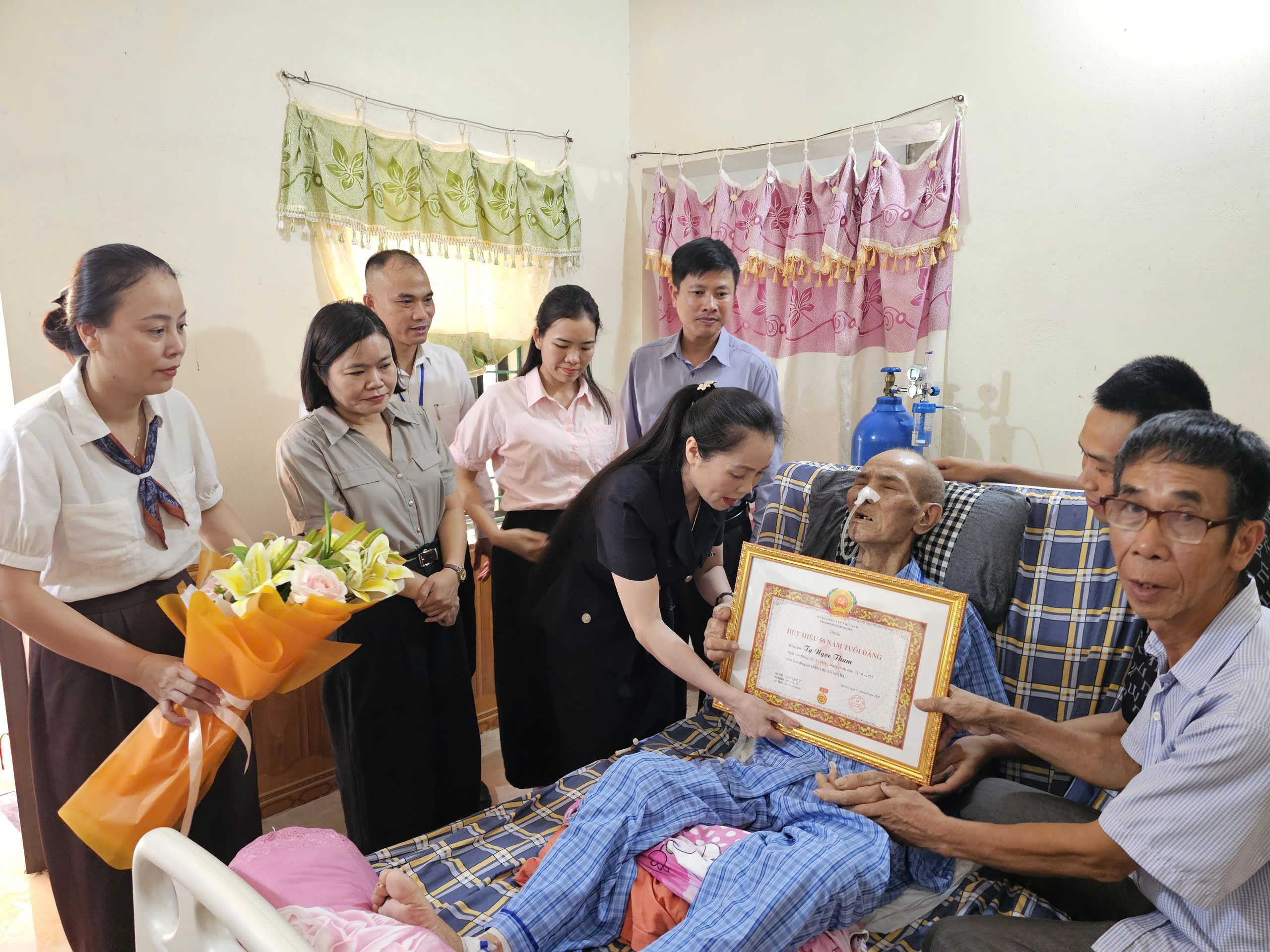 Phó Bí thư Thường trực Đảng ủy xã Nội Bài trao Huy hiệu 50 năm tuổi Đảng tặng đảng viên Tạ Ngọc Tham 