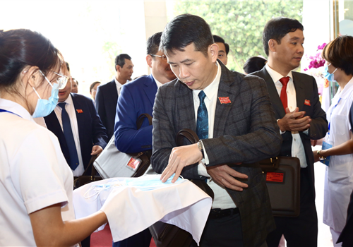 Các đại biểu thực hiện các biện pháp phòng, chống dịch bệnh trước khi vào Hội trường