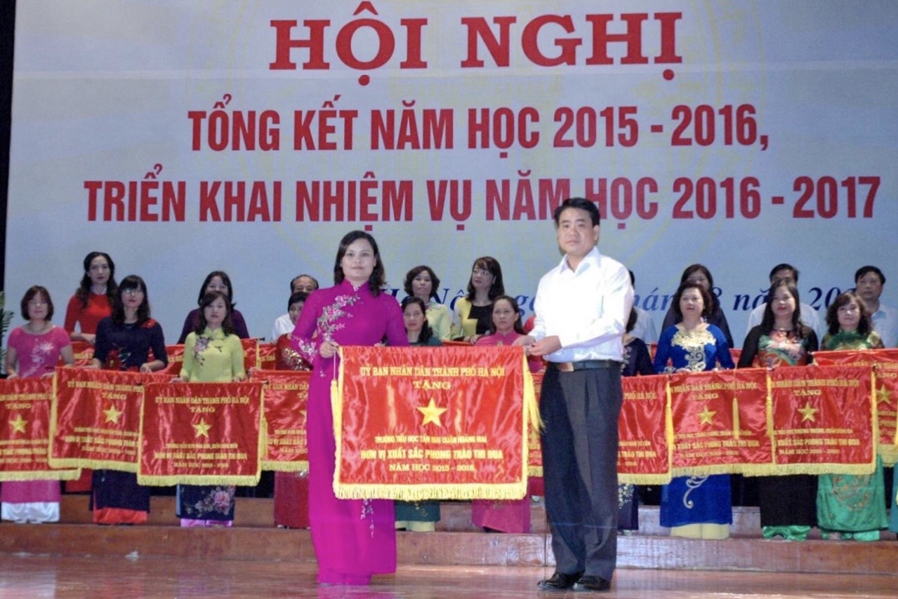 Cô giáo Nguyễn Thị Thương thay mặt trường TH Tân Mai nhận Cờ Thi đua do đồng chí Chủ tịch UBND Thành phố Nguyễn Đức Chung trao tặng