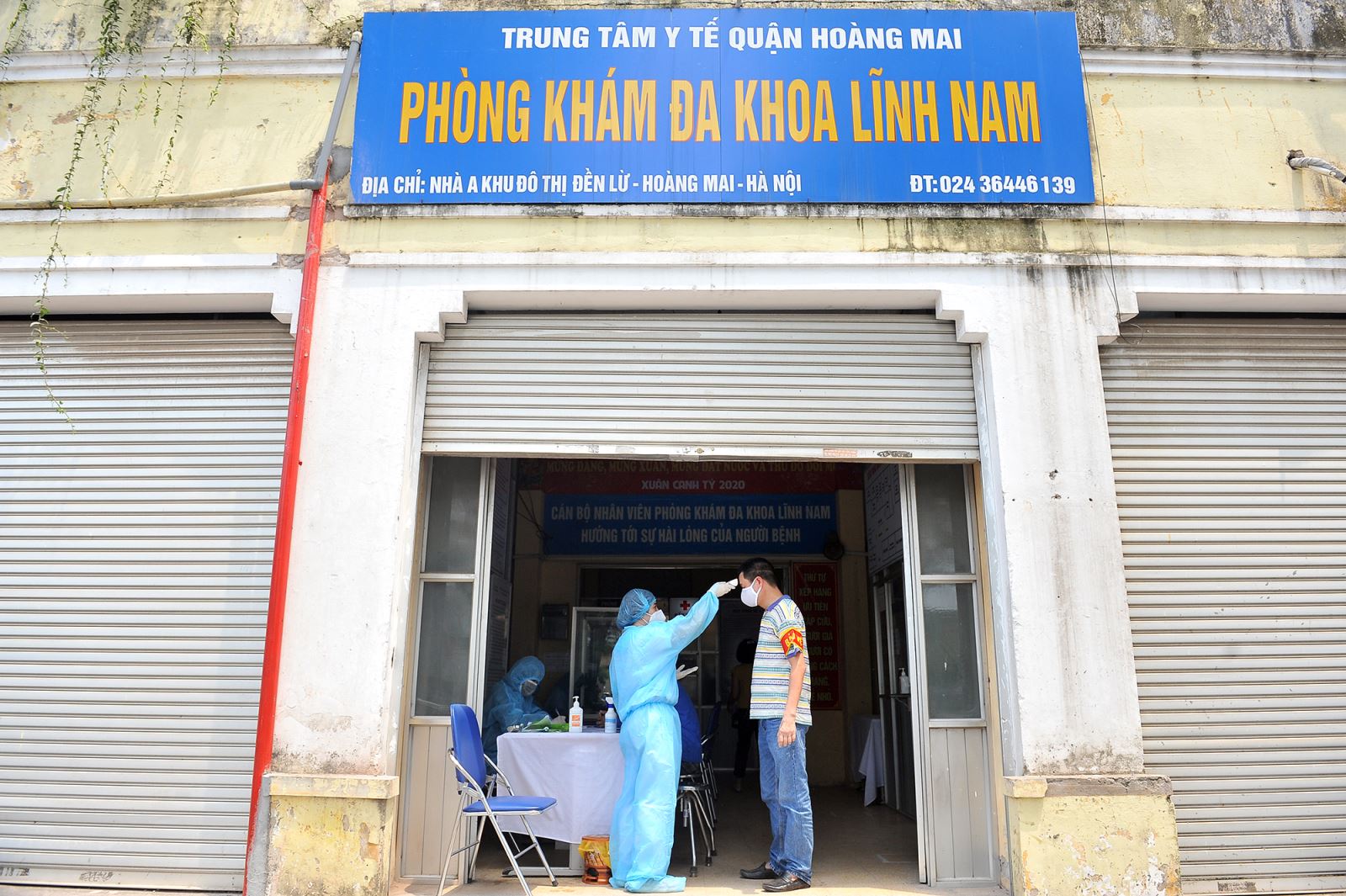 Nhân viên y tế đo thân nhiệt cho cán bộ quản lý chợ