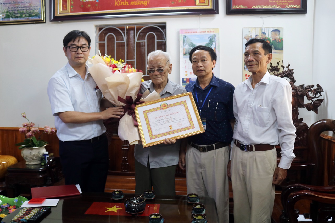 Ảnh: Đồng chí Bí thư Huyện ủy Nguyễn Văn Thắng trao tặng Huy hiệu 65 năm tuổi đảng cho đồng chí Mai Văn Sửu thuộc đảng bộ thị trấn Xuân Mai