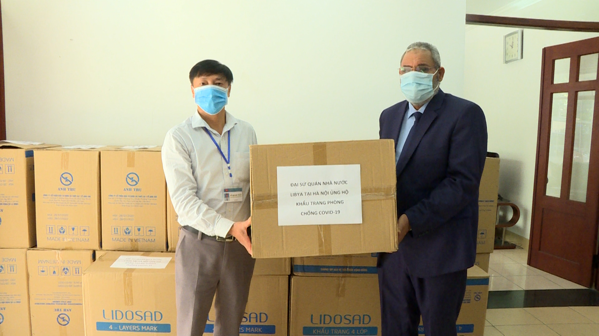 Đại diện lãnh đạo Ủy ban MTTQ huyện Ứng Hòa tiếp nhận khẩu trang do Đại sứ quán nước Libya trao tặng