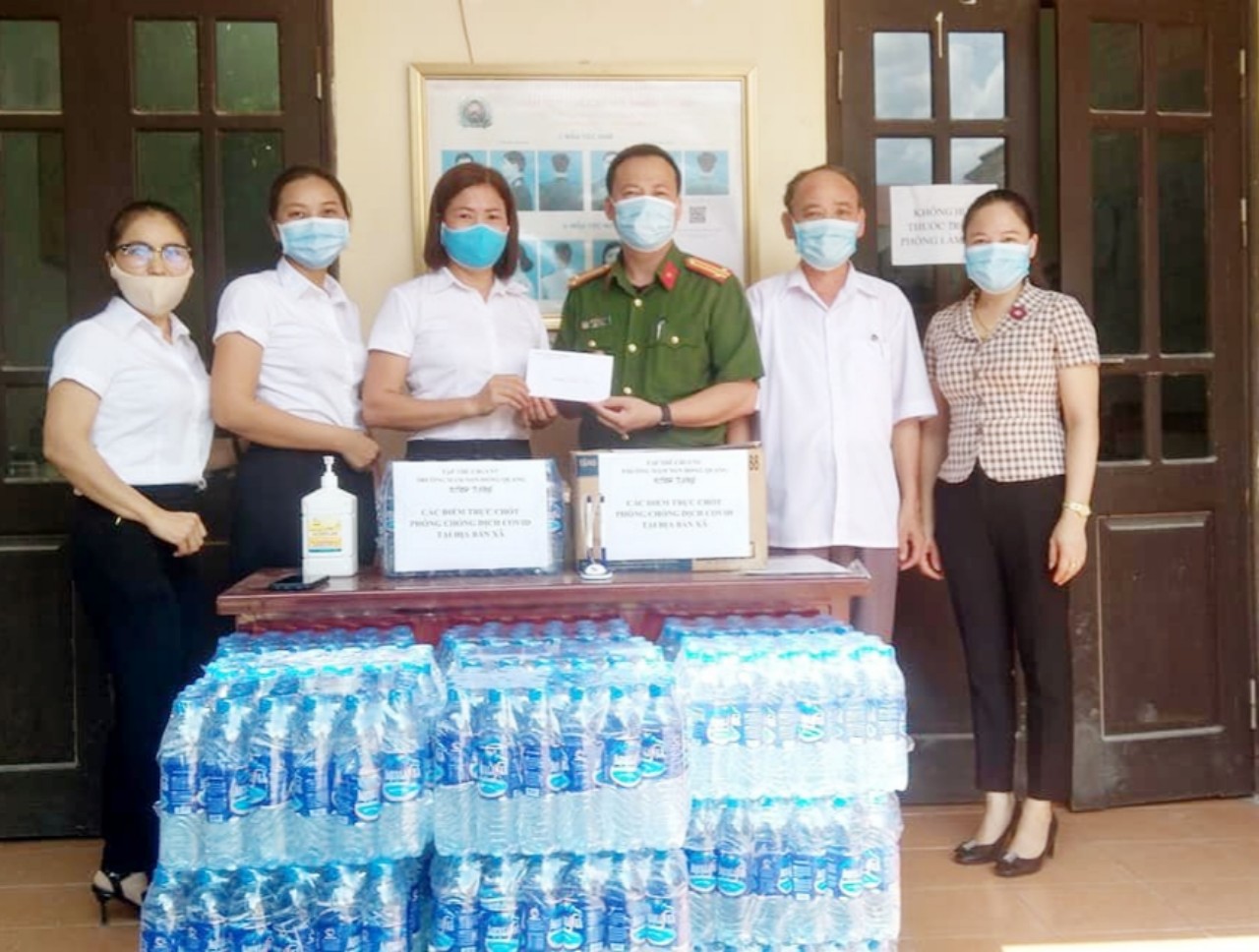 Cô Thủy (đứng thứ ba từ trái sang) cùng tập thể nhà trường tặng quà ủng hộ lực lượng công an xã Hồng Quang phòng chống Covid-19 trên địa bàn