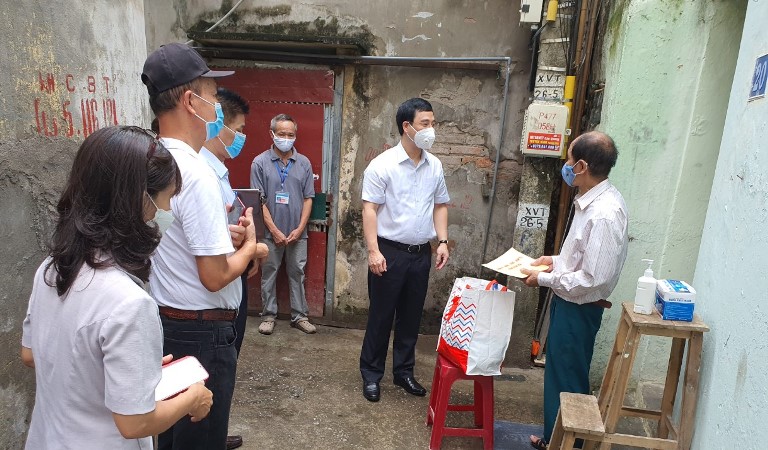 Chủ tịch UBND quận Hoàng Mai Nguyễn Minh Tâm động viên, trao quà cho hộ dân có hoàn cảnh khó khăn tại phường Vĩnh Hưng.