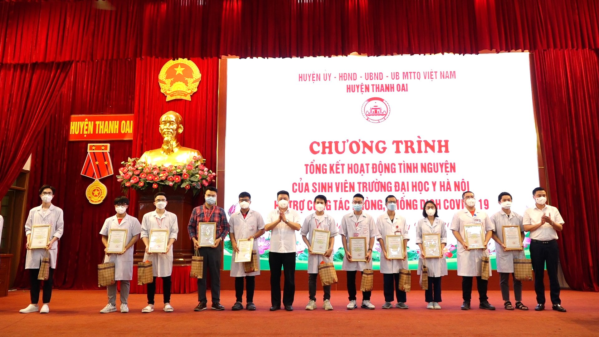 Đồng chí Bùi Hoàng Phan, Bí thư Huyện ủy trao quà và giấy chứng nhận có đóng góp tích cực trong công tác phòng chống dịch của huyện cho các bạn sinh viên tình nguyện