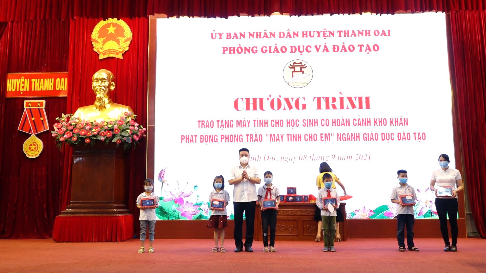 Đồng chí Bí thư Huyện ủy Bùi Hoàng Phan trao máy tính cho các học sinh có hoàn cảnh khó khăn