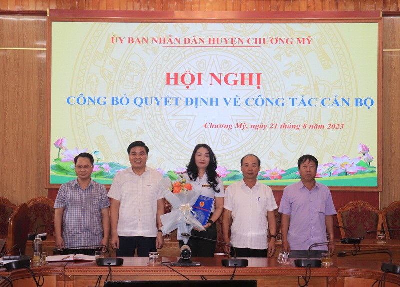 Ảnh: Các đồng chí Lãnh đạo UBND huyện trao quyết định và tặng hoa chúc mừng đồng chí Phùng Thị Thủy
