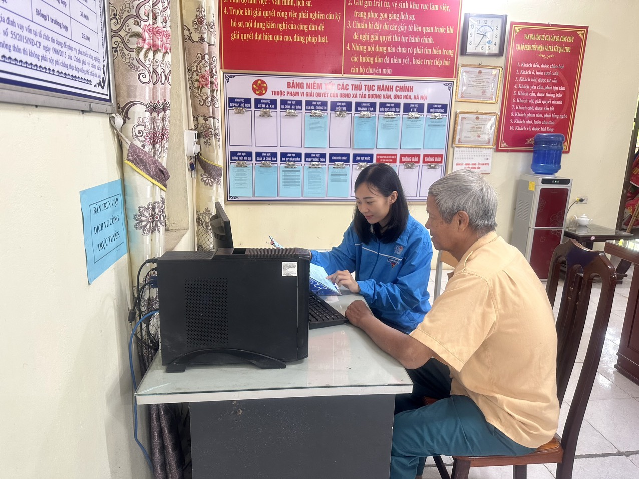 Cán bộ Đoàn thanh niên hướng dẫn người dân về các thủ tục hành chính và cách truy cập dịch vụ công trực tuyến mức độ 3,4 tại bộ phận Một cửa