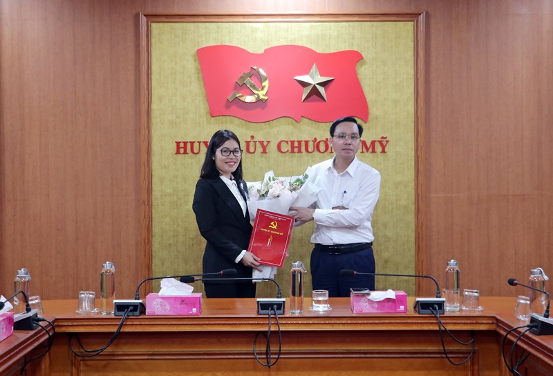 Đồng chí Trịnh Tiến Tường – Phó Bí thư thường trực Huyện ủy, Chủ tịch HĐND huyện trao quyết định, tặng hoa chúc mừng tân Phó chánh Văn phòng Huyện ủy