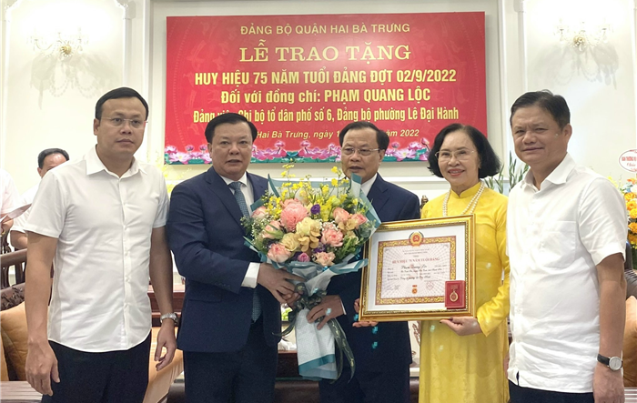 Bí thư Thành ủy Đinh Tiến Dũng trao Huy hiệu 75 năm tuổi Đảng cho đồng chí Phạm Quang Lộc và đồng chí Lê Thị Kim Quả